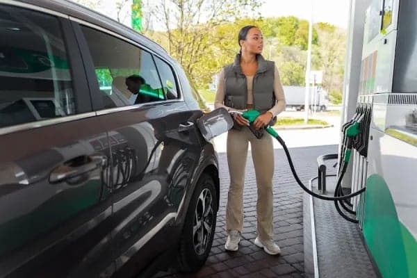 A customer refuelling a car on a service station forecourt